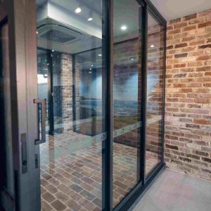 Close-up of modern stacking doors in a brick-walled showroom